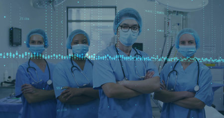 Posing medical team wearing blue scrubs under surgical lights in operating room, with stethoscopes. Medical, healthcare, team, professionalism, clinical, diagnostic, teamworkの写真素材