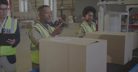 Scanning box on warehouse conveyor belt using scanner with coworker in hi-vis checking clipboard....