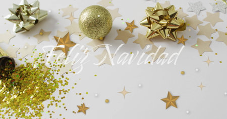 Feliz Navidad text image over Christmas decorations with stars and glitter. Holiday, festive, celebration, New Year, greeting, sparklesの写真素材