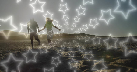 Running couple holding hands across sandy beach at sunset, with sun hat, glowing stars overlay. Romantic, silhouette, sunset, beach, serenity, admiration, harmonyの写真素材