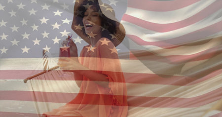 Smiling woman wearing coverup sitting on chair holding cocktail on shore. Fashion, leisure, vacation, outdoor, relaxation, stylish, celebrationの写真素材