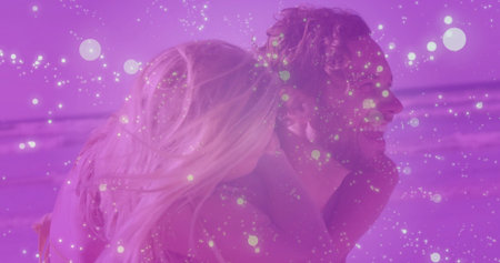 Carrying man in swim trunks holding woman in swim top along shoreline with sand, waves, horizon. Romance, leisure, friendship, relaxation, outdoor, scenic, joyfulの写真素材