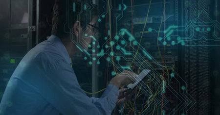 Crouching network engineer wearing tie configuring servers with cables in data center, copy space....