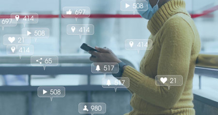 Woman in yellow sweater scrolling smartphone at terminal railing, window, with icons, copy space....