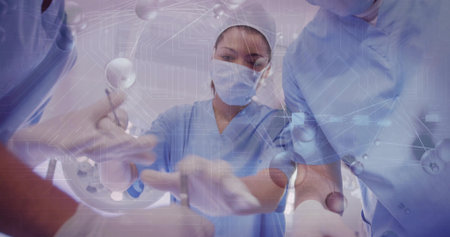 Performing surgery team wearing scrubs mask gloves in operating room, with digital overlays. Medical, innovation, biotechnology, precision, collaboration, futuristic, healthcareの写真素材