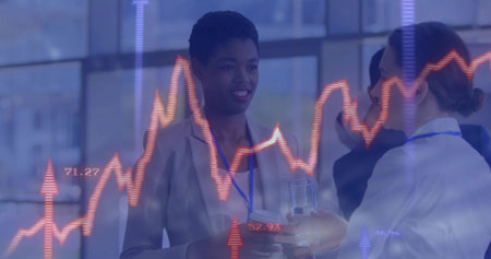 Smiling woman wearing beige-blazer blue-lanyard reviewing charts by windows, with chart overlay. Professional, business, corporate, networking, finance, modern, collaborativeの写真素材