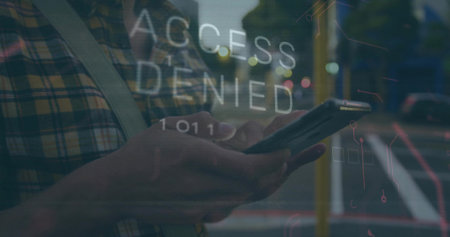 Man in shirt holding smartphone and reading ACCESS DENIED graphic on sidewalk, with crossbody strap. Security, urban, technology, communication, alert, notification, modernの写真素材