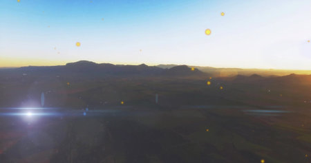 Showing dark mountain ridge against bright sunrise horizon, with valley textures and lens flare. Landscape, scenic, natural, serenity, tranquil, majestic, horizonの写真素材