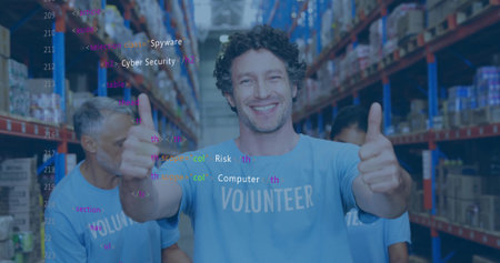 Smiling volunteer wearing blue T-shirt giving two thumbs up in warehouse with metal shelves....