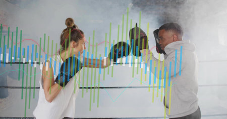 Female trainee punching focus mitts held by male coach in gym boxing ring, with digital charts....