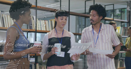 Reviewing documents three colleagues holding coffee cups by library shelves with badge lanyards....