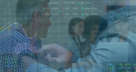 Fist bumping two professionals celebrating success around conference table, with financial charts. Collaboration, achievement, teamwork, corporate, digital, celebration, professionalismの写真素材