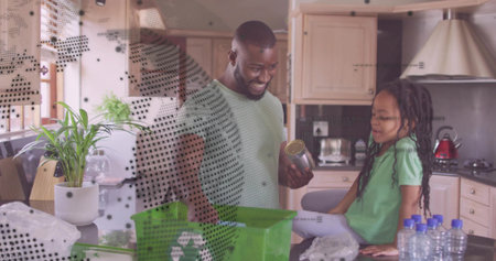 Sorting father and daughter placing recyclables on home kitchen counter, with green recycling bin. Family, sustainability, eco-friendly, homemaking, domestic, environmental, lifestyleの写真素材