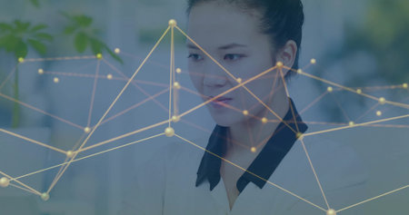 Office worker wearing blazer analyzing data on monitor and keyboard at office desk, network overlay. Technology, networking, professional, digital, modern, workspace, innovationの写真素材