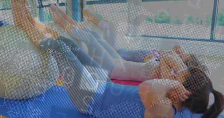 Performing crunches three women balancing on stability balls inside fitness studio on colored mats....