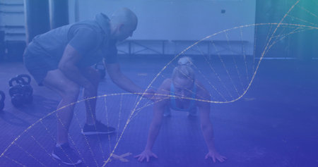Trainee holding push-up position on mat at gym, trainer guiding form with kettlebells weight rack. Fitness, training, strength, cardio, wellness, motivation, athleteの写真素材