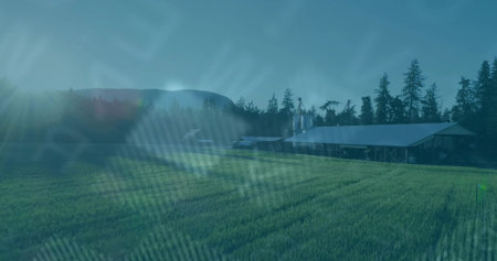 Showing metal-roof barn with silos by green crop field, evergreens and rolling hills, copy space....