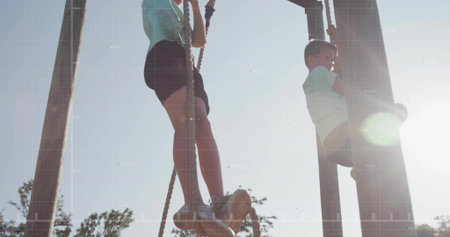 Climbing two boys scaling thick ropes on wooden structure at park, with athletic sneakers....