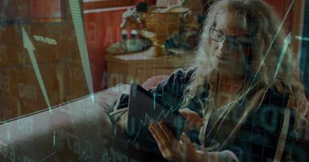 Analyzing investor in zip-up sweater holding tablet showing charts on couch at home, bison figurine....