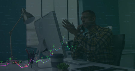 Holding smartphone, African American professional analyzing stock overlay on monitor at office desk....