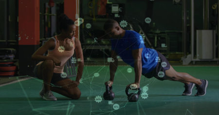 Trainer coaching male client doing push-ups using kettlebells in gym, copy space. Fitness, strength, training, workout, gym, endurance, conditioningの写真素材