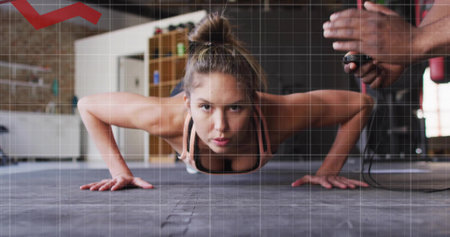 Holding pushup, woman in sports bra and leggings exercising on gym floor, with stopwatch timing....