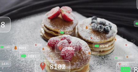 Floating chat, location pins and bell icons hovering over sugared pancakes with berries on tabletop....