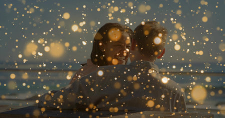 Sharing romantic moment couple embracing on beach bench, with golden light sparkles. Romance, intimacy, serenity, connection, tranquility, celebration, glowの写真素材