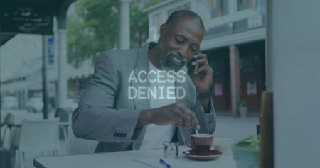 Executive in gray blazer stirring coffee and balancing smartphone in sidewalk cafe, laptop notebook. Corporate, professionalism, urban, leisure, modern, workspace, sophisticationの写真素材