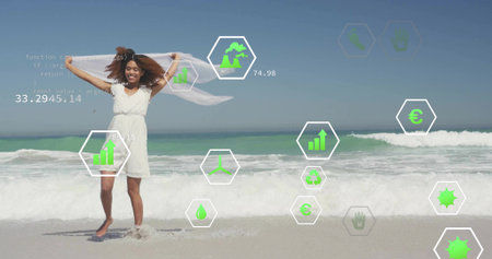 Woman standing holding white scarf overhead on beach shore. Environment, sustainability, eco-friendly, digital technology, renewable energy, climate, conservationの写真素材