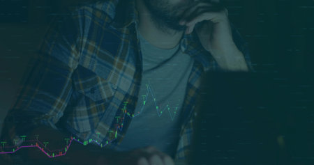 Leaning male in plaid shirt analyzing glowing finance charts on laptop in dim office, copy space....