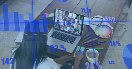 Working woman in white shirt interacting with team on laptop at home office, color wheel, pencils....