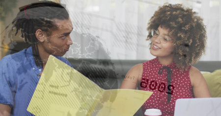 Coworkers reviewing documents in bright meeting room, with yellow folder and laptop. Collaboration,...