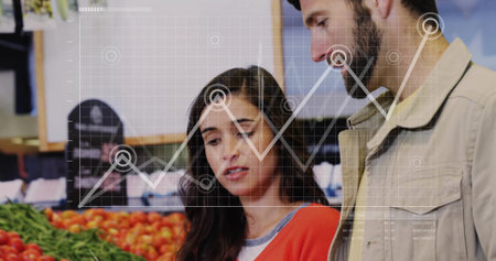 Shoppers comparing bins of fresh tomatoes and leafy greens in produce aisle, analyzing data overlay....