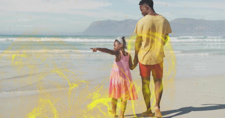 Father wearing yellow t-shirt holding daughter wearing headband on beach, waves, distant mountains. Family, outdoor, nature, leisure, adventure, relaxed, scenicの写真素材