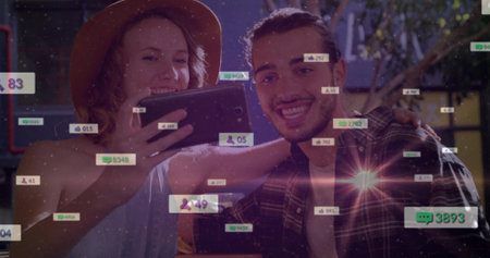 Smiling couple wearing hat and plaid shirt sharing tablet in cafe, with social media notifications. Romantic, intimate, trendy, lifestyle, casual, urban, cheerfulの写真素材