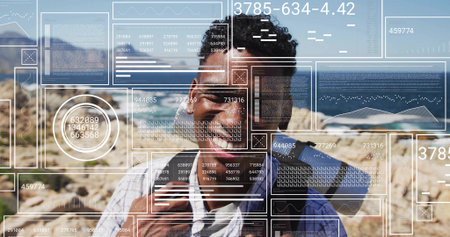 Standing smiling hiker gripping blue backpack on rocky coastal trail at midday, with data overlays. Adventure, exploration, technology, outdoor, panoramic, dynamic, modernの写真素材