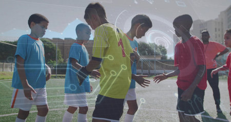 Exchanging high-fives soccer players holding soccer ball on turf field with goal net. Athletics,...