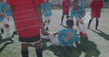 Sliding boy in light blue jersey tackling soccer ball on artificial turf field, competitive match. Athletic, teamwork, competition, stadium, youth, sport, outdoorの写真素材
