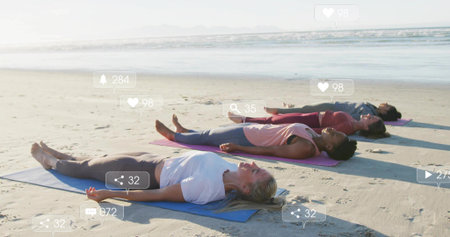 Lying four women practicing yoga pose on sandy shoreline, with colored mats. Wellness, mindfulness,...