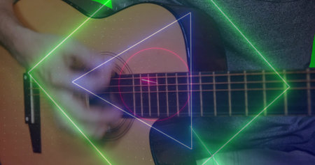Right forearm and hand strumming acoustic guitar in dimly lit studio, with neon geometric overlays. Music, performance, instrumentation, digital art, ambient, creative, entertainmentの写真素材
