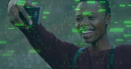 Smiling woman wearing maroon sweater taking selfie with smartphone in field. Portrait, technology, casual, nature, digital, communication, lifestyleの写真素材