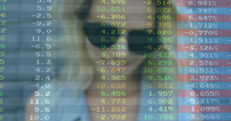 Businesswoman wearing sunglasses studying stock data in office, with transparent digital screen. Finance, technology, futurism, corporate, analysis, professional, innovationの写真素材
