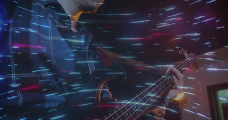 Bassist musician playing electric bass guitar in rehearsal room, with amplifier and light streaks. Musicians, band, performance, entertainment, stage, nightlife, artisticの写真素材