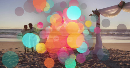 Standing newlywed couple wearing wedding attire, gazing beach sunset at floral arch, copy space. Romance, celebration, elegance, serenity, coastal, boho, festiveの写真素材
