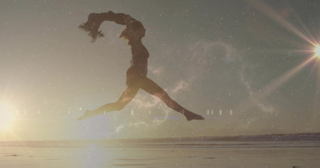 Woman silhouette leaping on wet sandy beach at sunrise, with glowing outline, lens flares....