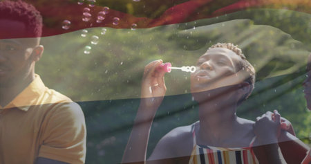 Blowing woman in sundress creating bubbles in sunlit garden, with pink bubble wand striped overlay....