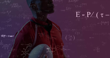 Standing athlete in red jersey holding oval ball in studio, floating scientific symbols, copy space. Athlete, sports, fitness, energy, innovation, science, technologyの写真素材