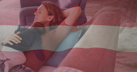 Reclining mother cradling sleeping baby on sofa with cushions in living room, patterned rug. Comfort, relaxation, intimacy, cozy, nurturing, domestic, serenityの写真素材