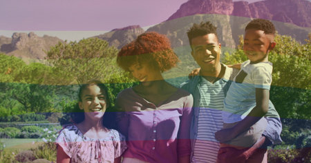 Standing family of four in spring outfits in landscaped garden, with flowering shrubs and mountains. Family, outdoor, landscape, lifestyle, natural, togetherness, vibrantの写真素材